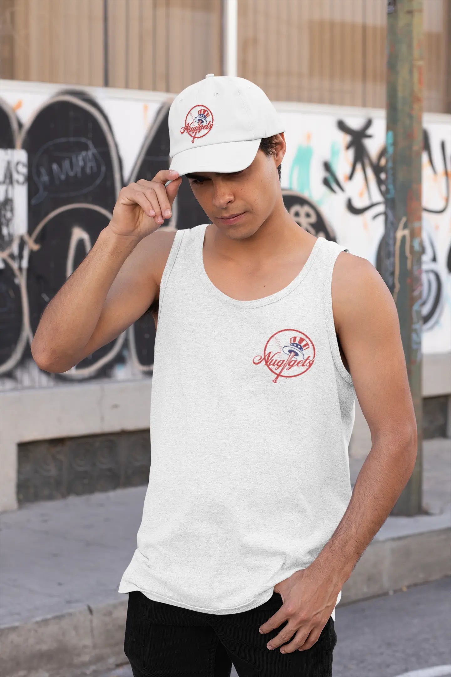 Man tipping his whitw New York Nuggets dad hat while wearing a matching tank top in an urban streetwear setting