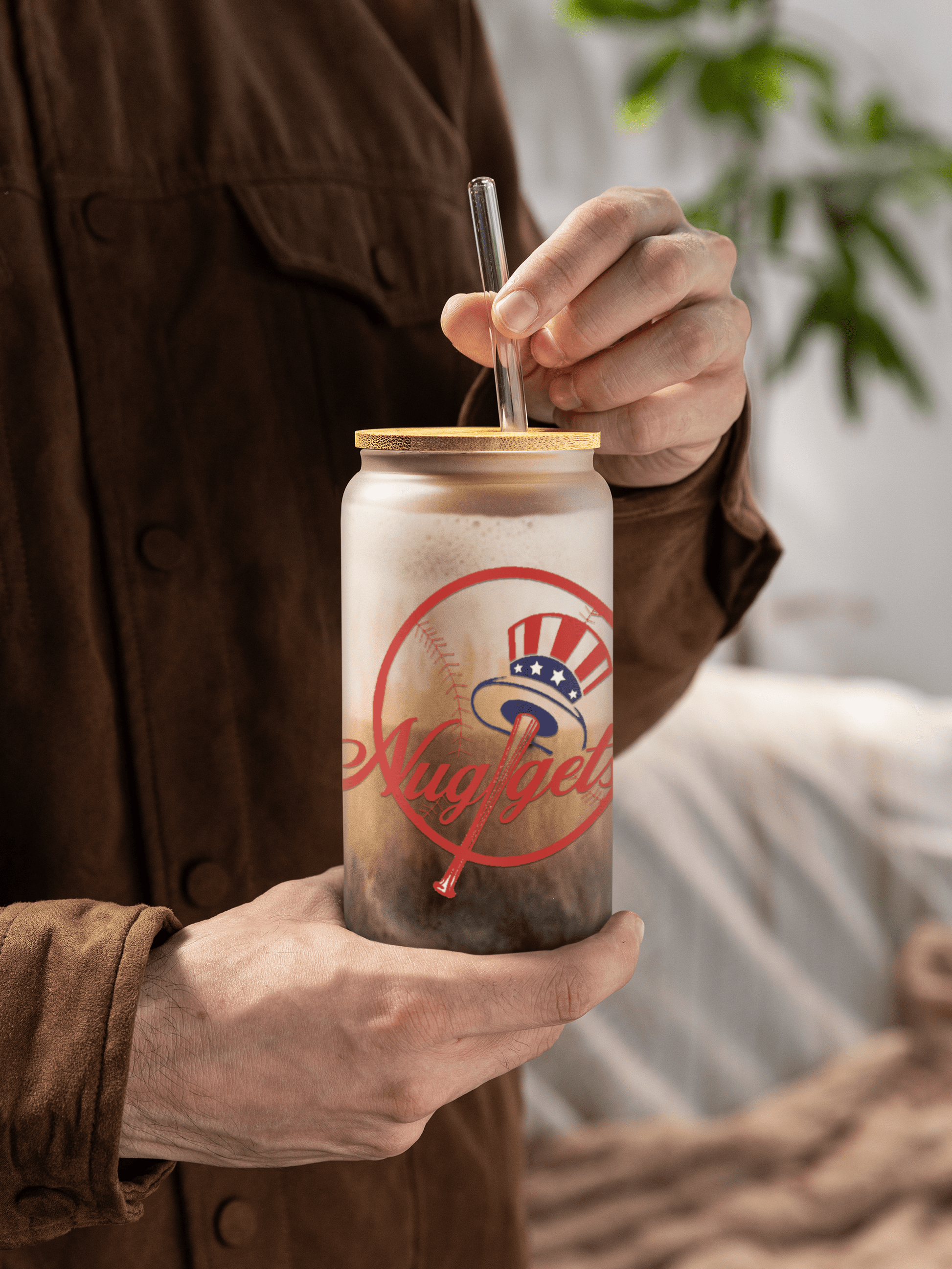 Man holding the glass filled with iced coffee topped with foam
