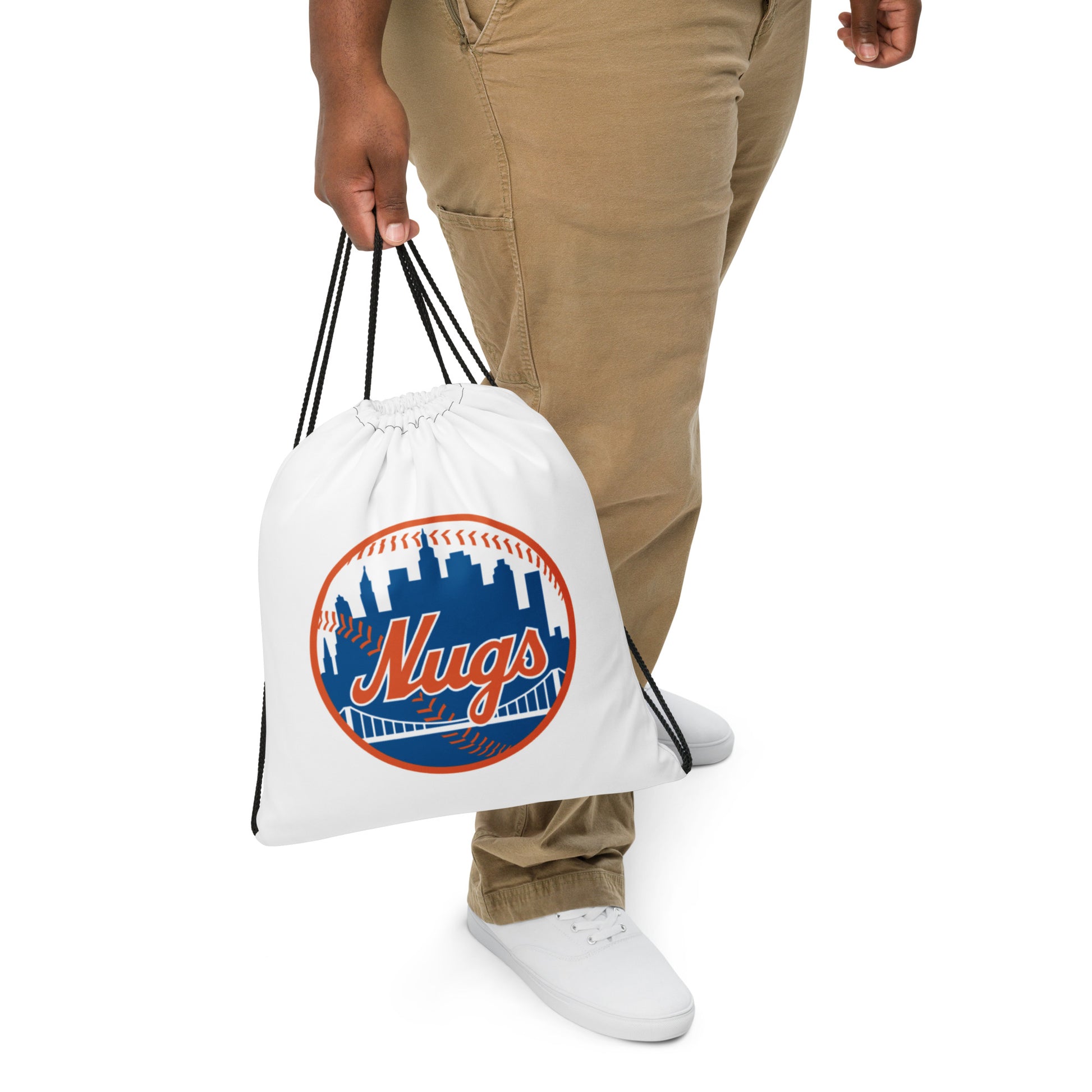 A man holding a white drawstring bag with the New York Nugs logo featuring a blue city skyline and orange baseball stitches.