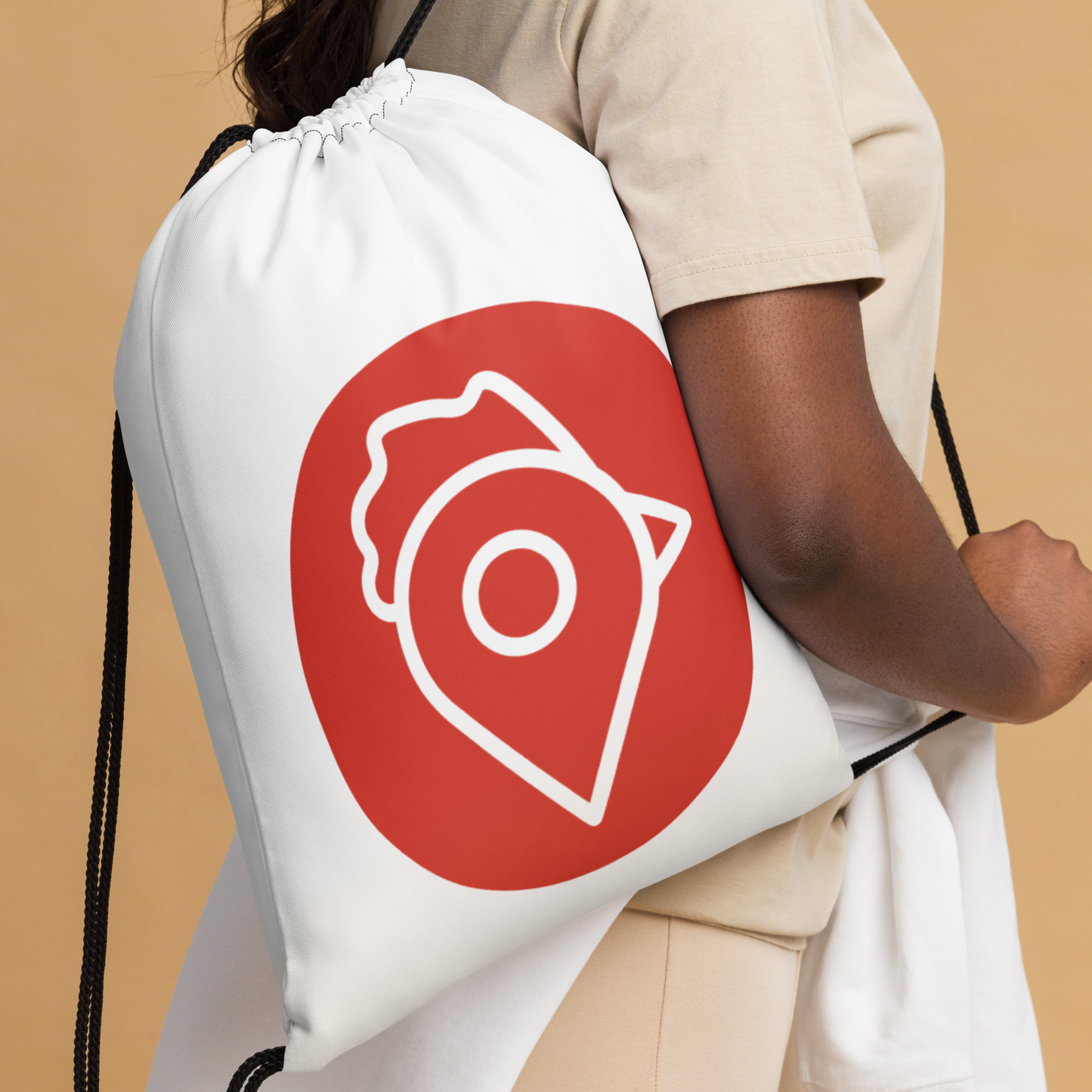 Person carrying The Nugget Spot Signature drawstring bag on shoulder, white bag with red logo