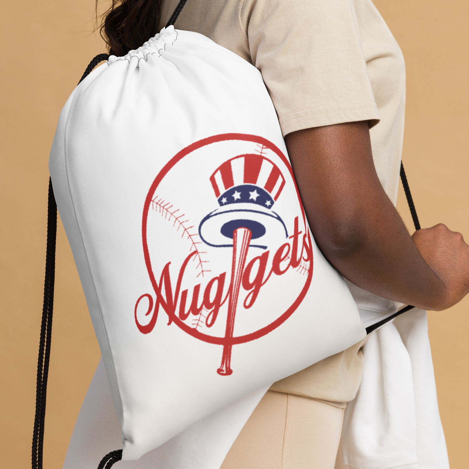 Person holding a white New York Nugget drawstring bag with red and blue baseball logo.