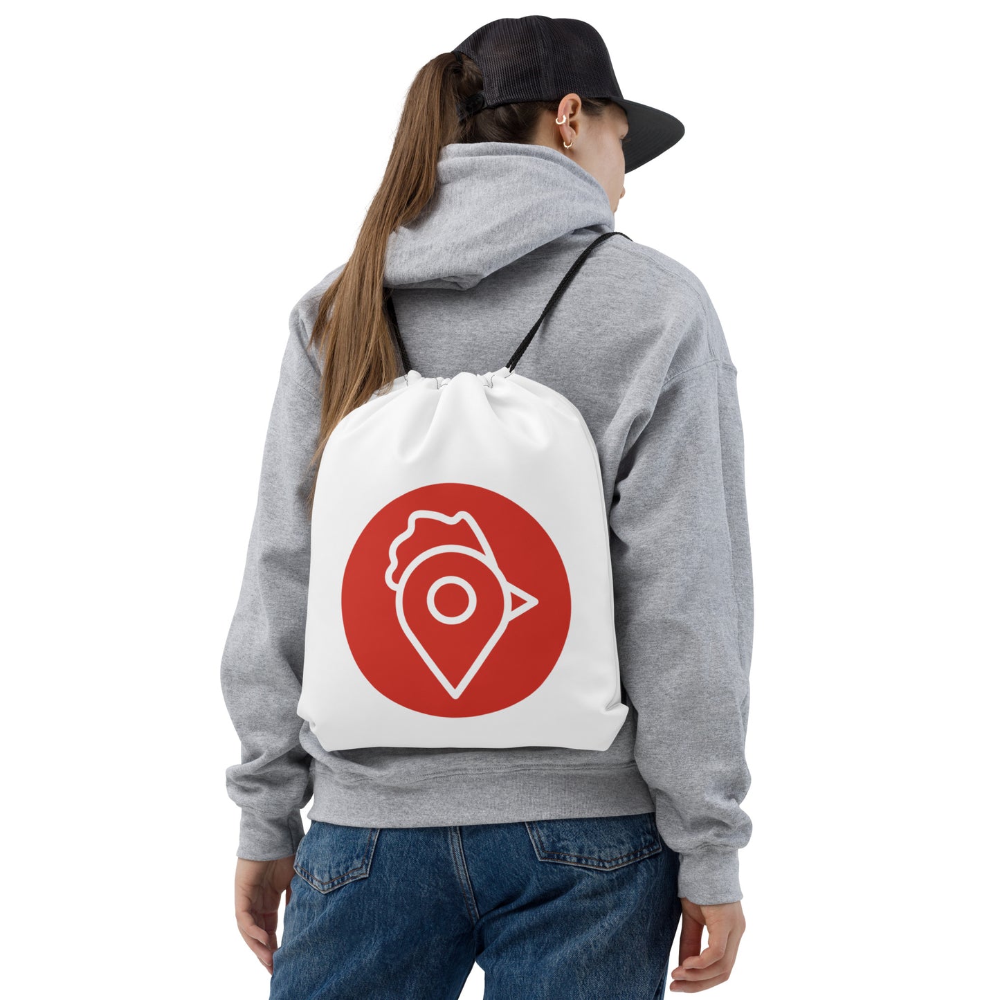 Woman wearing gray hoodie and cap carrying The Nugget Spot Signature drawstring bag on her back