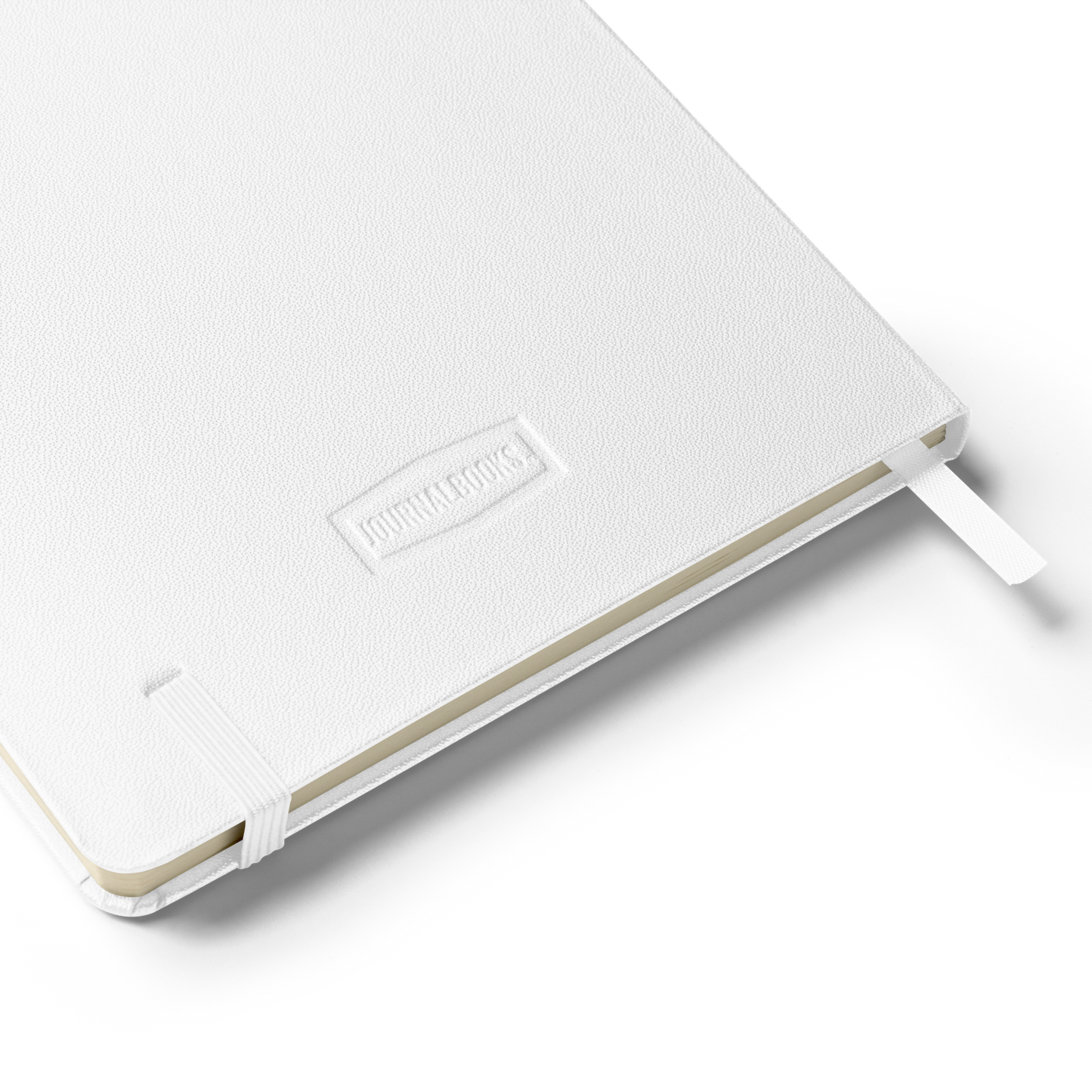 Close-up of the notebook’s white textured back cover embossed with “JournalBooks” logo and elastic strap
