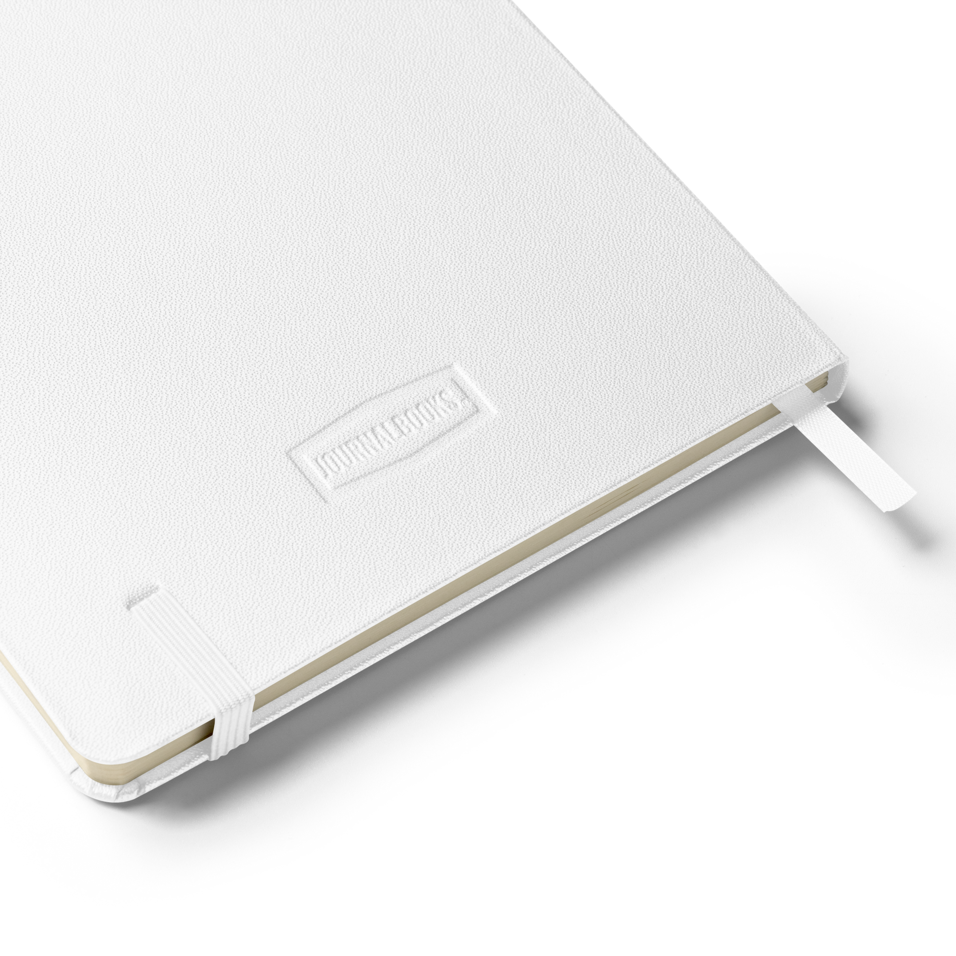 Close-up of the notebook’s white textured back cover embossed with “JournalBooks” logo and elastic strap