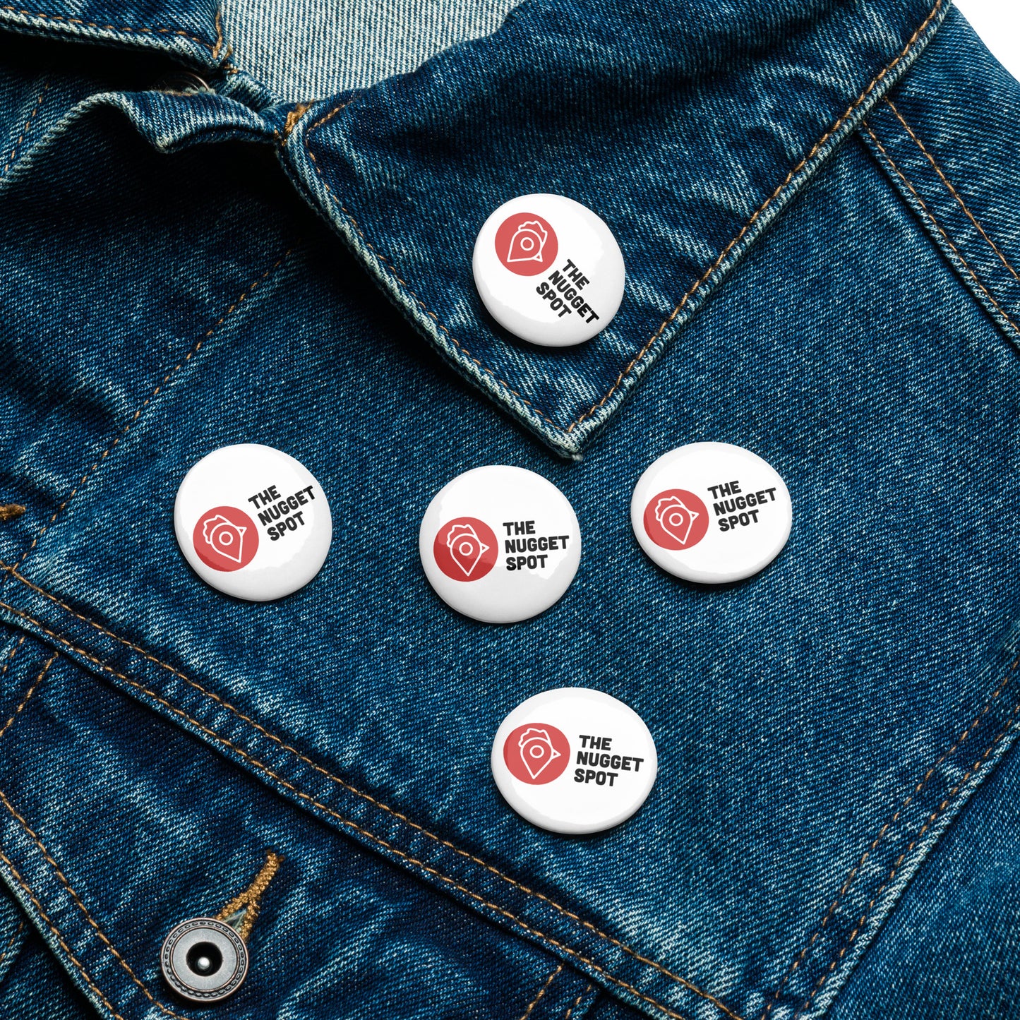 The Nugget Spot 5-Pack Pin Buttons displayed on a blue denim jacket for a stylish streetwear look.